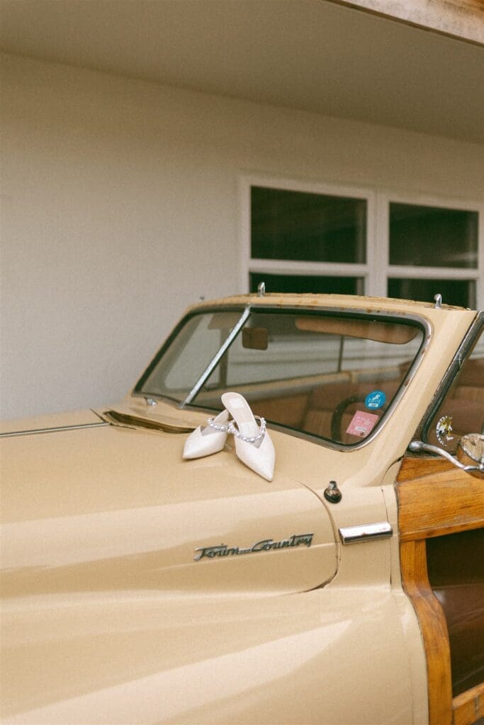 Brides wedding shoes on a vintage car captured in 35mm film