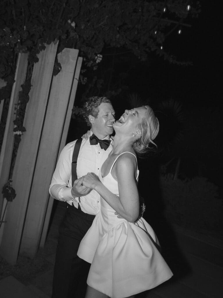 Bride and groom laugh during their Acre wedding reception in Cabo