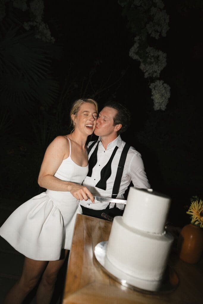 Bride and groom cut cake during their Acre wedding reception in Cabo