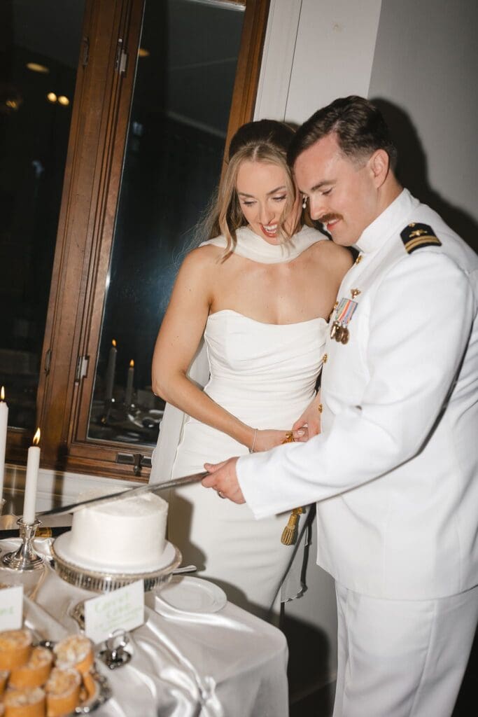 Bride and groom cuts their cake with a sword